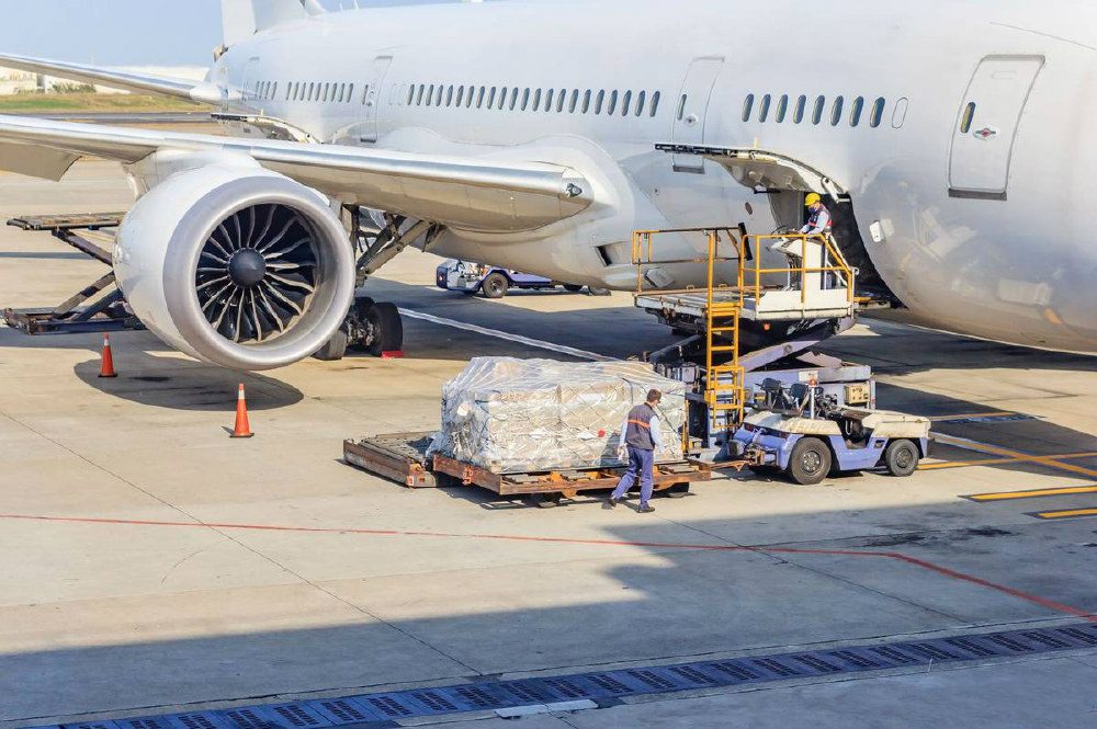 Air freight being loaded beside a cargo aircraft